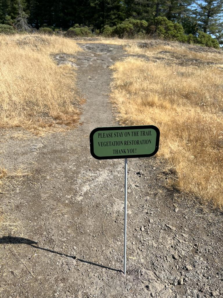 Sign post: please stay on the trail!
